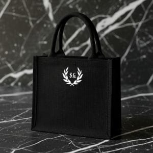 Bolso MINI MAJESTIC de yute negro personalizado con Corona de Laureles y iniciales estampadas a mano en Barcelona.