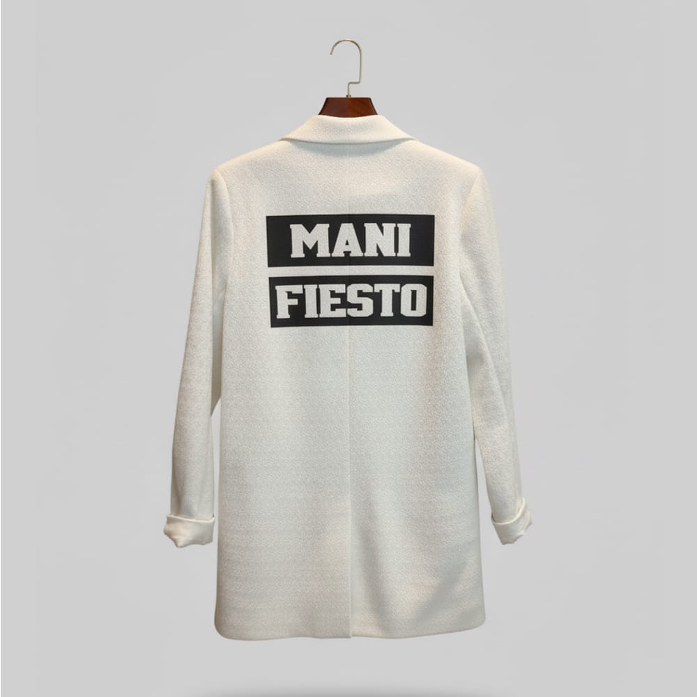 “Espalda de Blazer Manifiesto con vinilo negro MANIFIESTO y parche STORM UNIT en la manga, prenda numerada de edición limitada.”